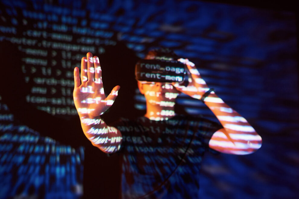 Double exposure of a caucasian man and Virtual reality headset is presumably a gamer or a hacker cracking the code into a secure network or server, with lines of code Segurança de rede