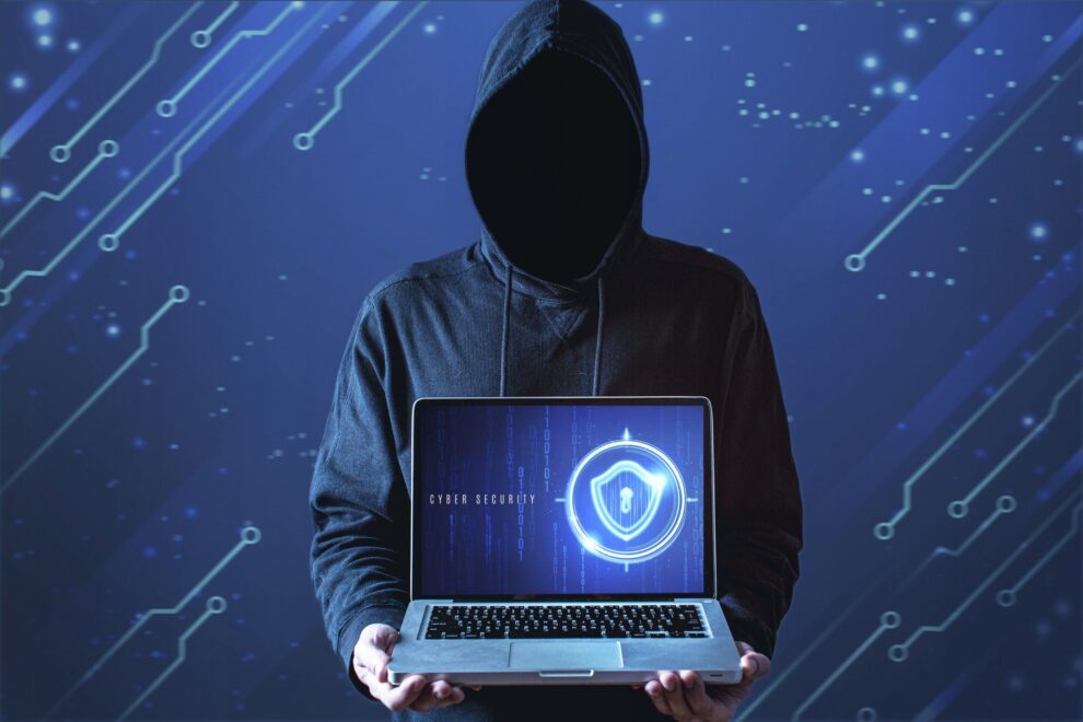 homem-tiro-medio-com-capuz-segurando-laptop Ataques cibernéticos