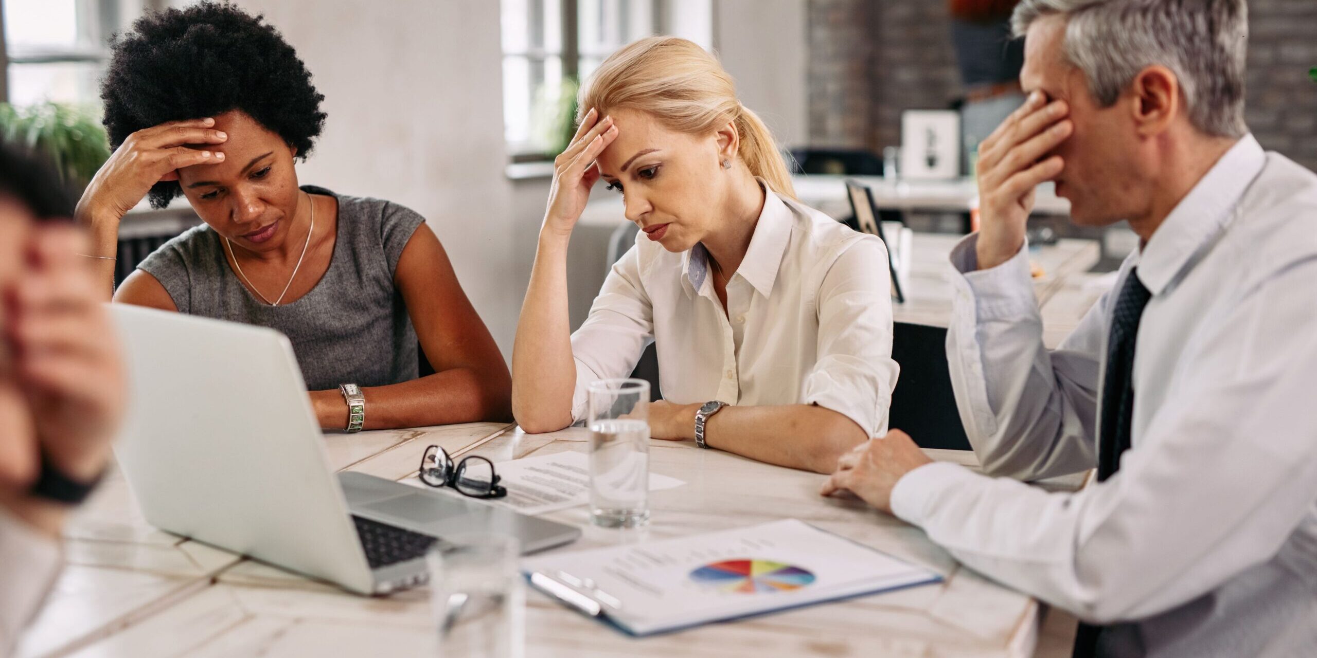 group-business-colleagues-having-headache-while-working-laptop-trying-solve-problems-meeting